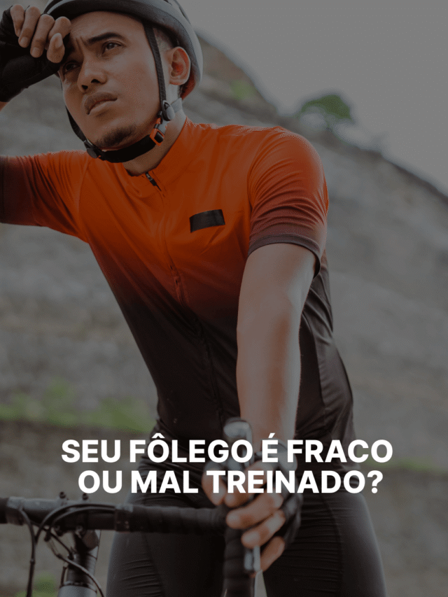 Ciclista pedalando em subida com expressão de esforço e respiração intensa durante treino.